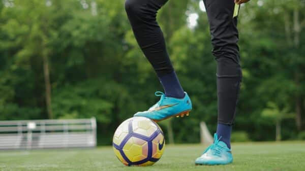 person in blue nike soccer shoes and black pants