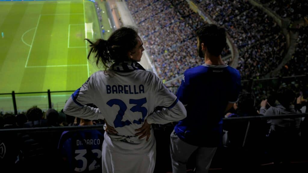 a couple of people that are standing in front of a soccer field
