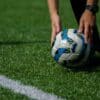 a soccer ball being held by a person on a field