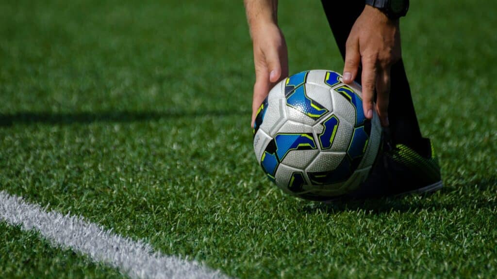 a soccer ball being held by a person on a field
