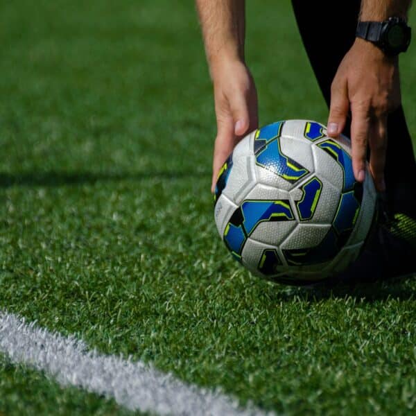 a soccer ball being held by a person on a field
