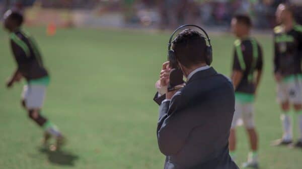 selective focus photography of man using headphones near athletes