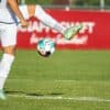 a man kicking a soccer ball on a field