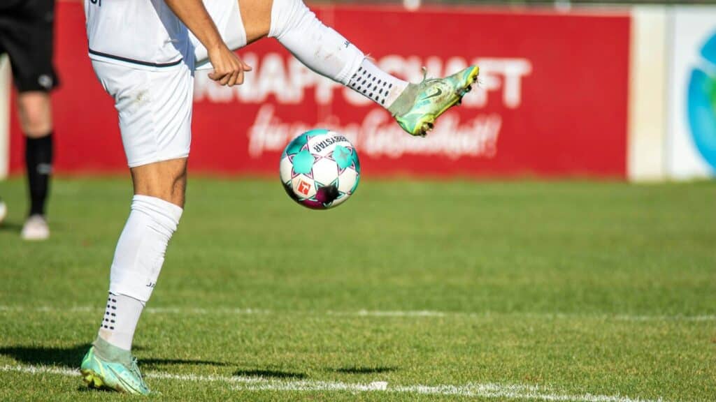 a man kicking a soccer ball on a field