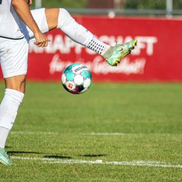 a man kicking a soccer ball on a field