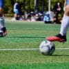 a couple of people that are kicking a soccer ball