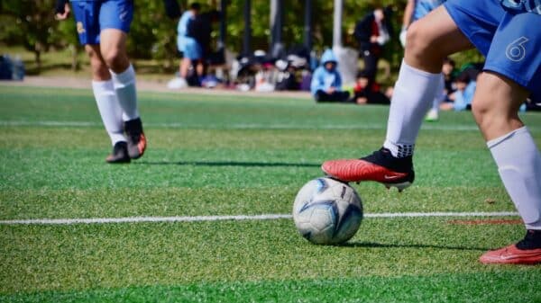 a couple of people that are kicking a soccer ball