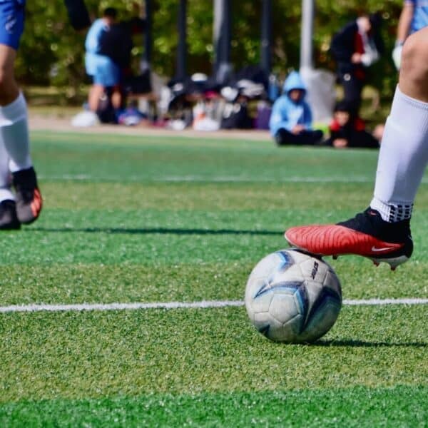 a couple of people that are kicking a soccer ball