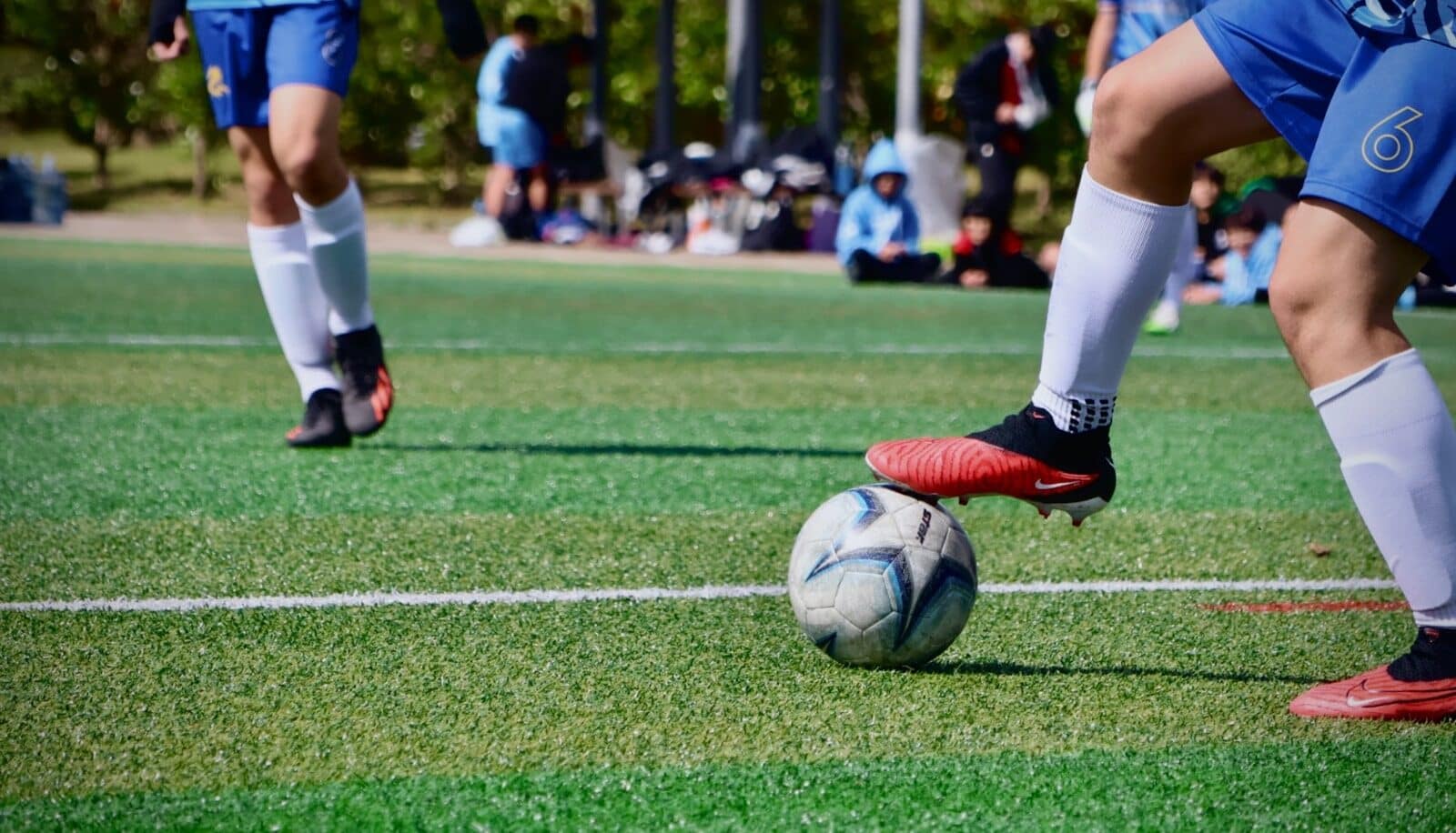 a couple of people that are kicking a soccer ball